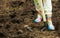 Woman in rubber boots digging ground