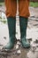 Woman in rubber boots standing in a puddle