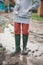 Woman in rubber boots standing in a puddle