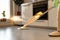 Woman in rubber gloves using microfiber spray mop pad and refillable bottle with cleaning solution, mopping the floor in apartment