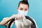 Woman rubs the steering wheel of a car with an antiseptic napkin