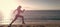 Woman run and jump on sea beach. Energetic running woman in activewear run on beach sand along seaside, runner.