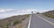 Woman Runner - Determined Woman Jogging On Mountain Road Against Cloudy Sky