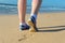Woman runner legs in shoes on beach