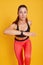 Woman runner posing isolated over yellow studio background, dynamic movement, fit lady working out in gym, wearing bra and leggins