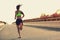 Woman runner running on city bridge road