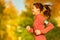 Woman runner running in fall autumn forest