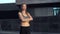 Woman runner standing before exercising urban city background