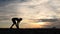 Woman runner tying shoelaces on seaside at sunset