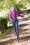 Woman running along autumn path