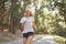 Woman running asphalt road summer park