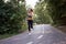 Woman running asphalt road summer park