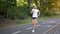 Woman running asphalt road summer park