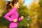 Woman running in autumn fall forest