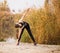 Woman running in autumn fall forest. Healthy lifestyleYoung sportive woman doing exercises in autumn. Sportswoman stretching