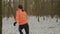 Woman running away from somebody in forest. Back side follow view of female runs in park at winter. Confident concentrated girl ru