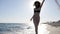 Woman running on beach in Backlight, slow motion, happy girl on swimsuit, background sand and sea, running along beach,