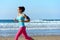 Woman running on beach with earphones