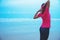 Woman running exercises on the beach in morning stretching arm relax and happy on beach
