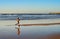 Woman running ocean beach sunset