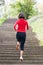 Woman running on park stairs