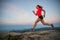 Woman running on rocks. Female cross country running in mountains.