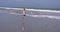 Woman running on the shore with blue skies