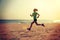 Woman running on sunrise sandy beach