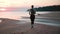 Woman running sunset sunrise sand beach healthy lifestyle outdoor cardio activity back view slowmo