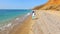 A woman runs along the coastline and the camera follows her.