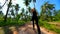 Woman Runs Along a Scenic Road With Palm Trees on Tropical Island, Thailand