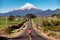 Woman runs on a straight road toward snow mountain. Running outdoors concept.