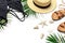 Woman`s beach accessories flat lay. Round trendy rattan bag straw hat black swimsuit leather sandals tropical palm leaves