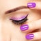 Woman\'s eye with violet eye makeup and nails
