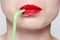 Woman\'s face with red lipstick and green straw