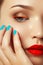 Woman`s face with vivid make-up and colorful nail polish