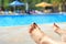 Woman\'s feet with blurred sunny swimming pool in background