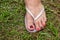 Woman`s feet with slipper, nails painted black and red.