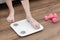 Woman`s feet stepping on electronic scales