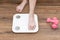 Woman`s feet stepping on electronic scales