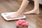 Woman`s feet stepping on electronic scales