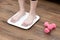 Woman`s feet stepping on electronic scales