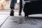 A woman`s feet while traveling and dragging a black baggage in the outdoors