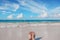 Woman`s feet on the tropical Caribbean beach. Ocean and blue sky