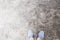 Woman`s feet in walking shoes on asphalt road. Industrial concrete floor top view photo