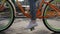 Woman\'s feets and pedals of a bright moving bicycle focus in in summer evening