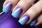 Woman\\\'s fingernails with blue and purple ombre colored nail polish design