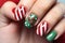 Woman\\\'s fingernails with green and red colored nail polish with seasonal Christmas themed design
