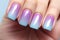 Woman\\\'s fingernails with pastel blue, pink and purple ombre colored nail polish design