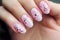 Woman\\\'s fingernails with pink seasonal spring cherry tree flower nail art design